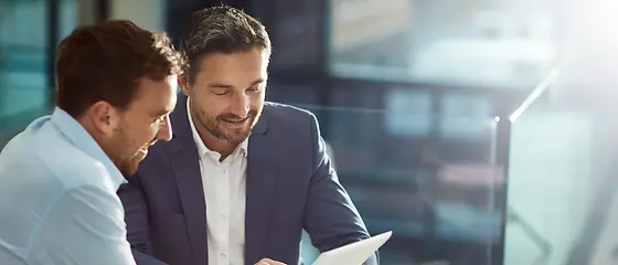 Zwei Männer in einer Besprechung - Hanse Business Compact Zwei Männer sitzen an einem Tisch und schauen auf ein Tablet.