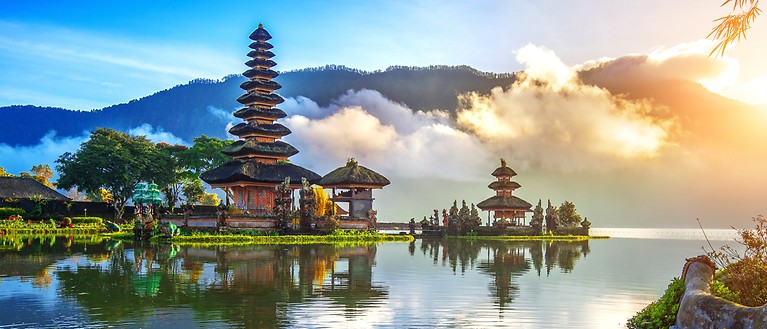 Man erkennt einen kleinen zierlichen Tempel, der von Wasser umgeben ist. Im Hintergrund sind tief schwebende Wolken.