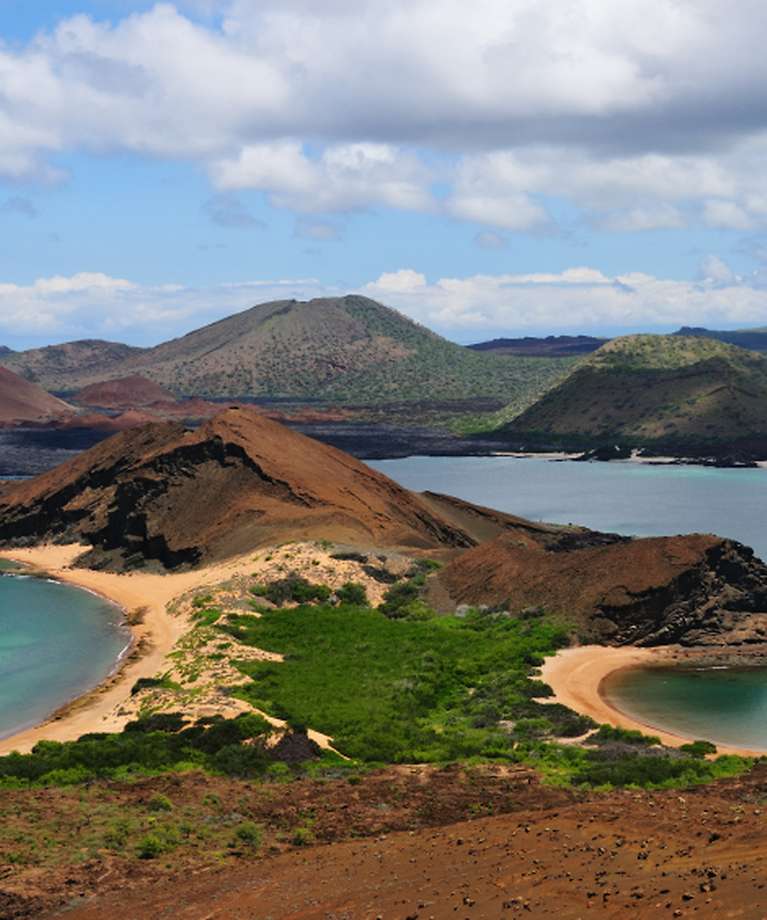 Man erkennt die Galapagosinseln. Im Hintergrund sind Berge zu sehen. Links und rechts ist Wasser.