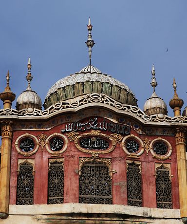 Man sieht eine alte Moschee, die mit vielen kleinen Details verziert ist.