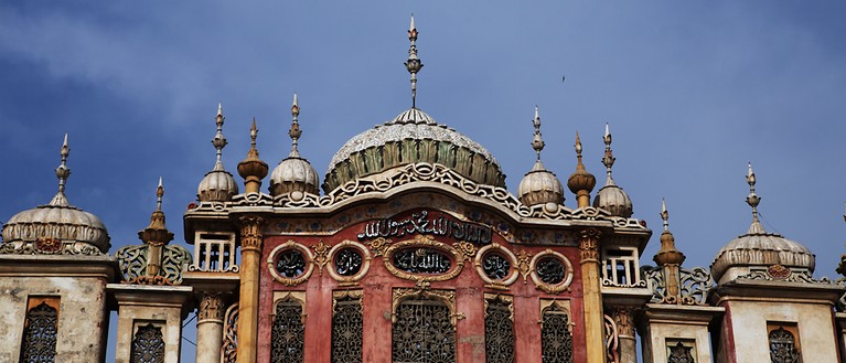 Man sieht eine alte Moschee, die mit vielen kleinen Details verziert ist.