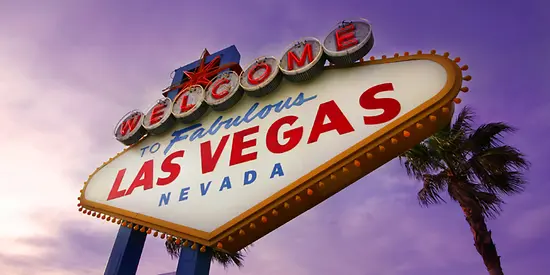 Man erkennt ein riesiges Schild auf dem "Welcome to fabulous Las Vegas Nevada" steht. 