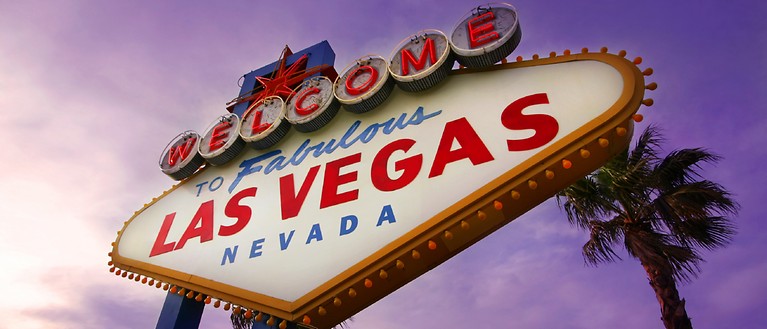 Man erkennt ein riesiges Schild auf dem "Welcome to fabulous Las Vegas Nevada" steht. 