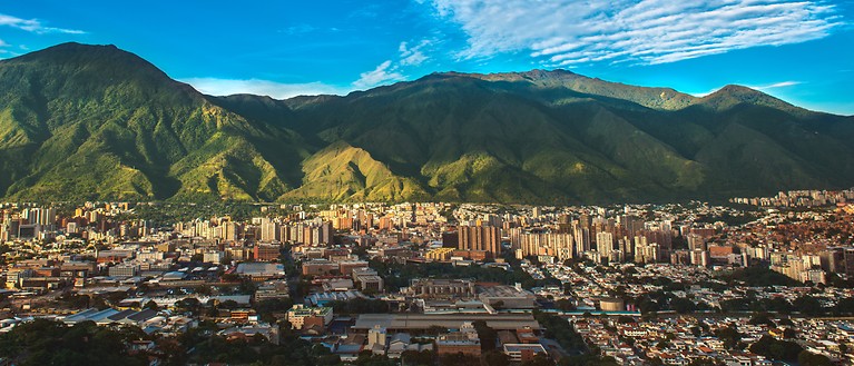 Man sieht die Hauptstadt Caracas und eine Berglandschaft im Hintergrund.