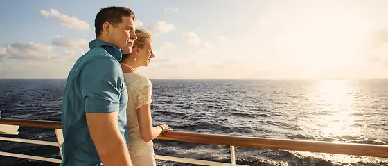 Pärchen auf einem Schiff - Schiffsreise Reiserücktrittsversicherung Ein Pärchen steht an der Reling und guckt auf das Wasser.