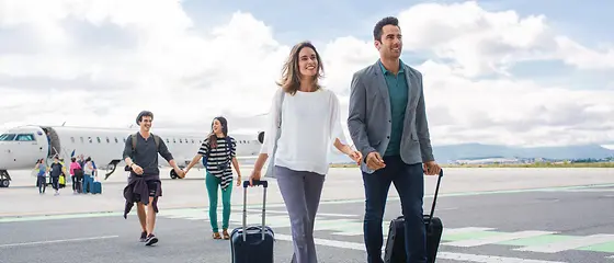 Eine Familie geht auf dem Rollfeld. Im Hintergrund kann man ein Flugzeug sehen. 
