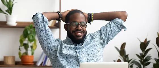 Mann lehnt hinter Schreibtisch lehnt sich im Stuhl zurück - Steuerbescheinigung