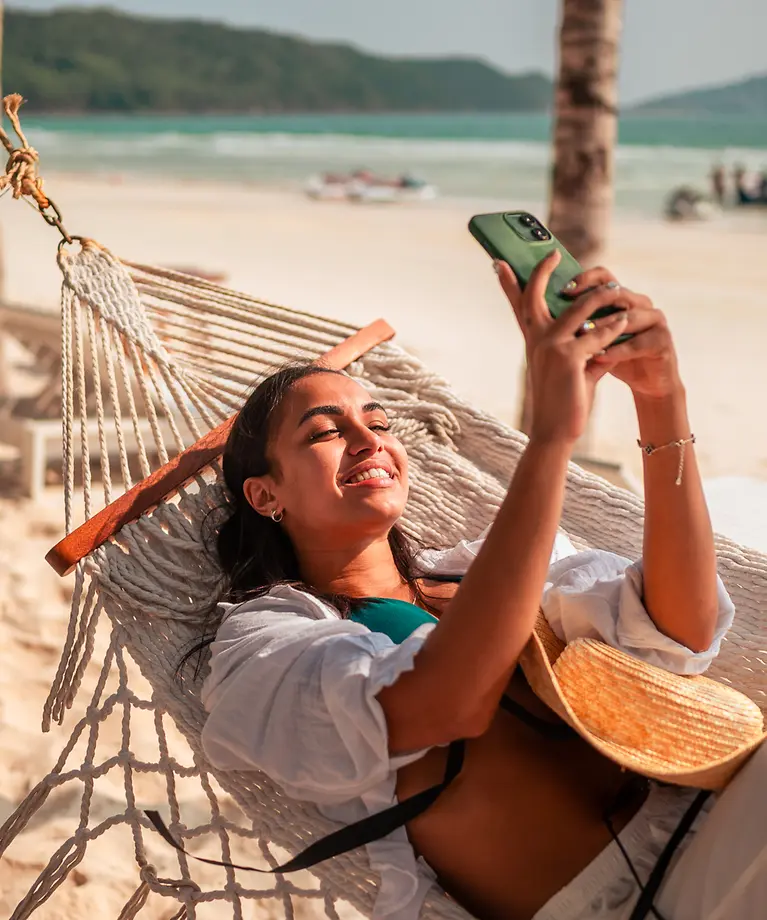 Frau entspannt sich am Strand in einer Hängematte