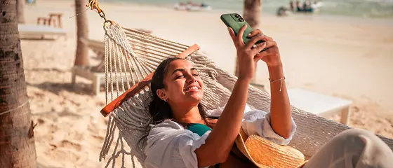 Frau entspannt sich am Strand in einer Hängematte