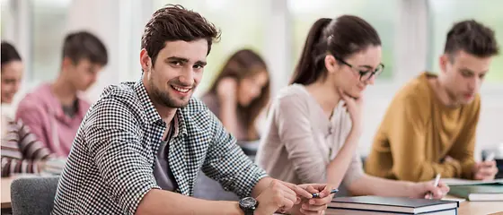 Schüler im Klassenraum - Erasmus Reiseschutz Sechs Personen sitzen in einem Raum und lernen.