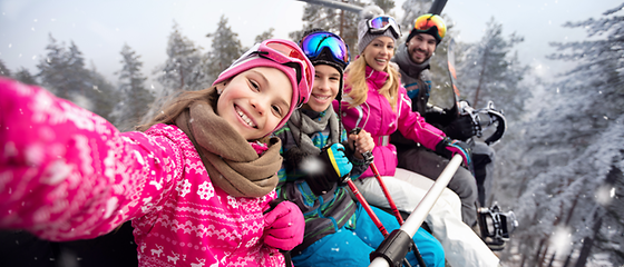 Familie im Lift - Skiurlaub  Eine Familie sitzt in einem Skilift und machen ein Selfie.